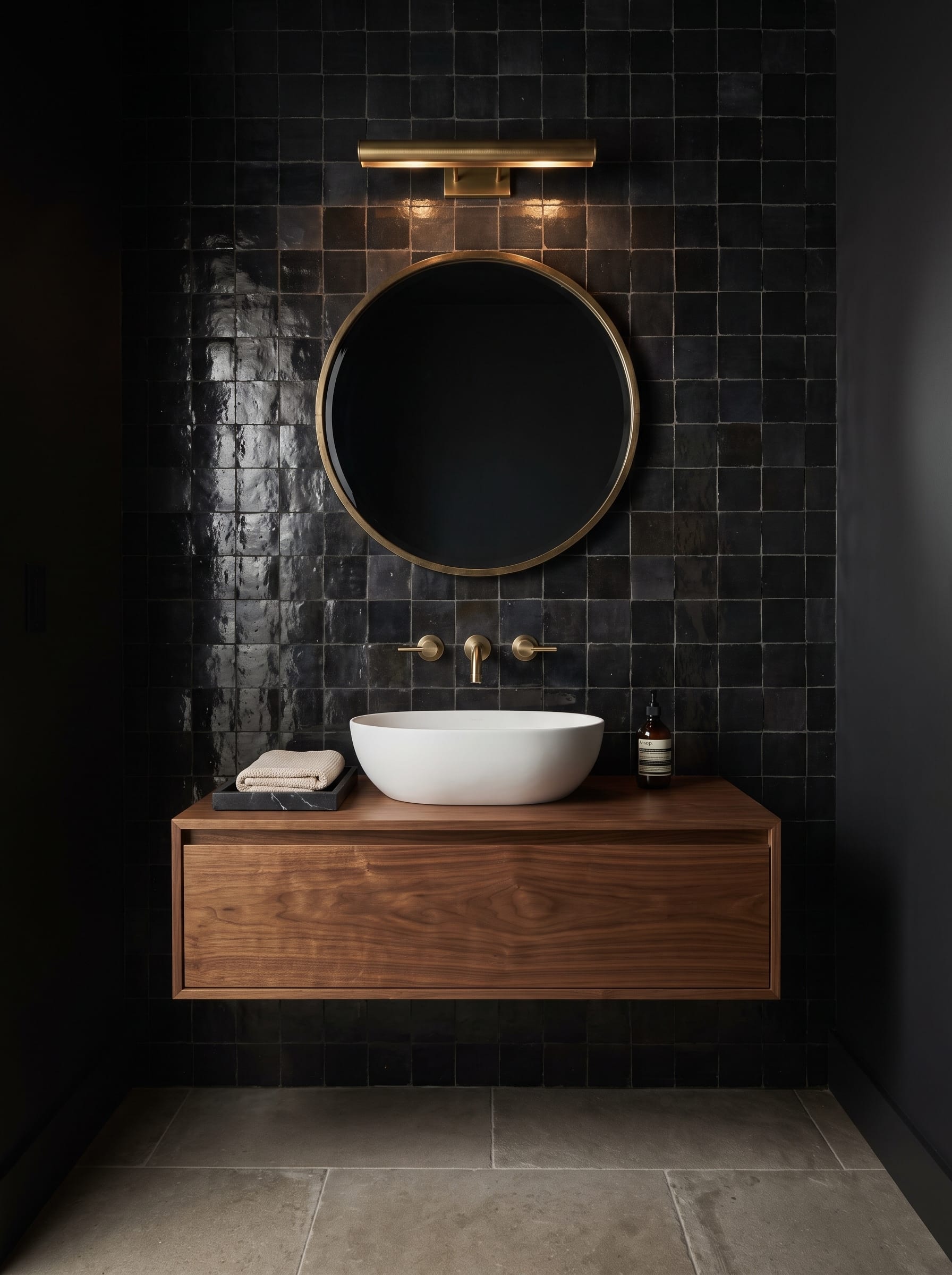 Black Zellige-style tile bathroom with a floating walnut vanity and white vessel sink shown in bright daylight and warm evening lighting.