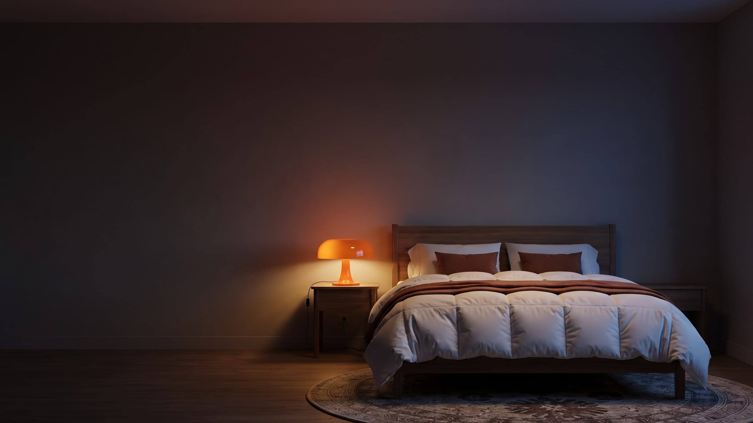 Bedroom with a white box-stitched comforter, rust cushions and throw, an orange glass mushroom lamp on a wood nightstand and a brown medallion round rug.