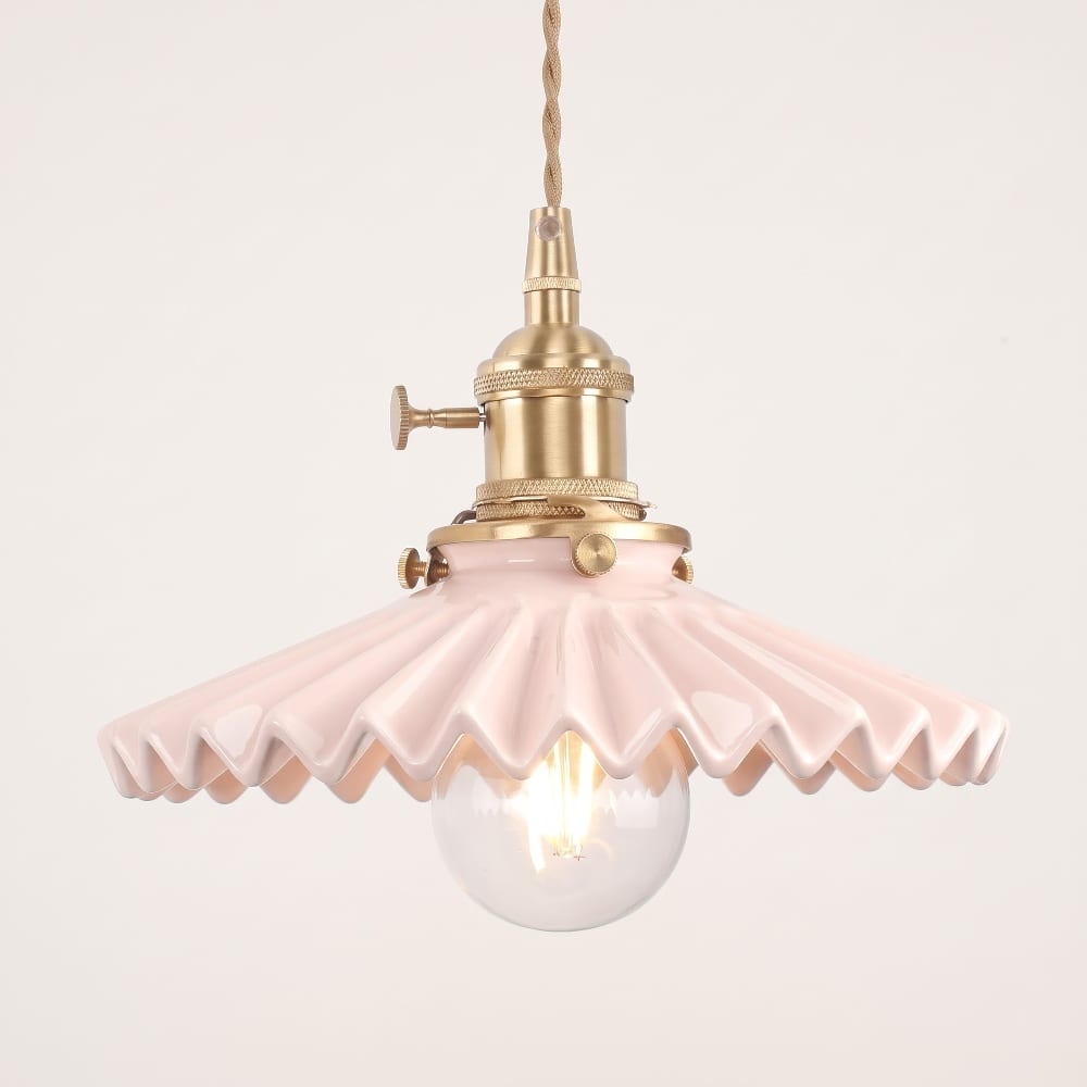 Pink pleated scalloped pendant light with a brass socket and a clear globe bulb