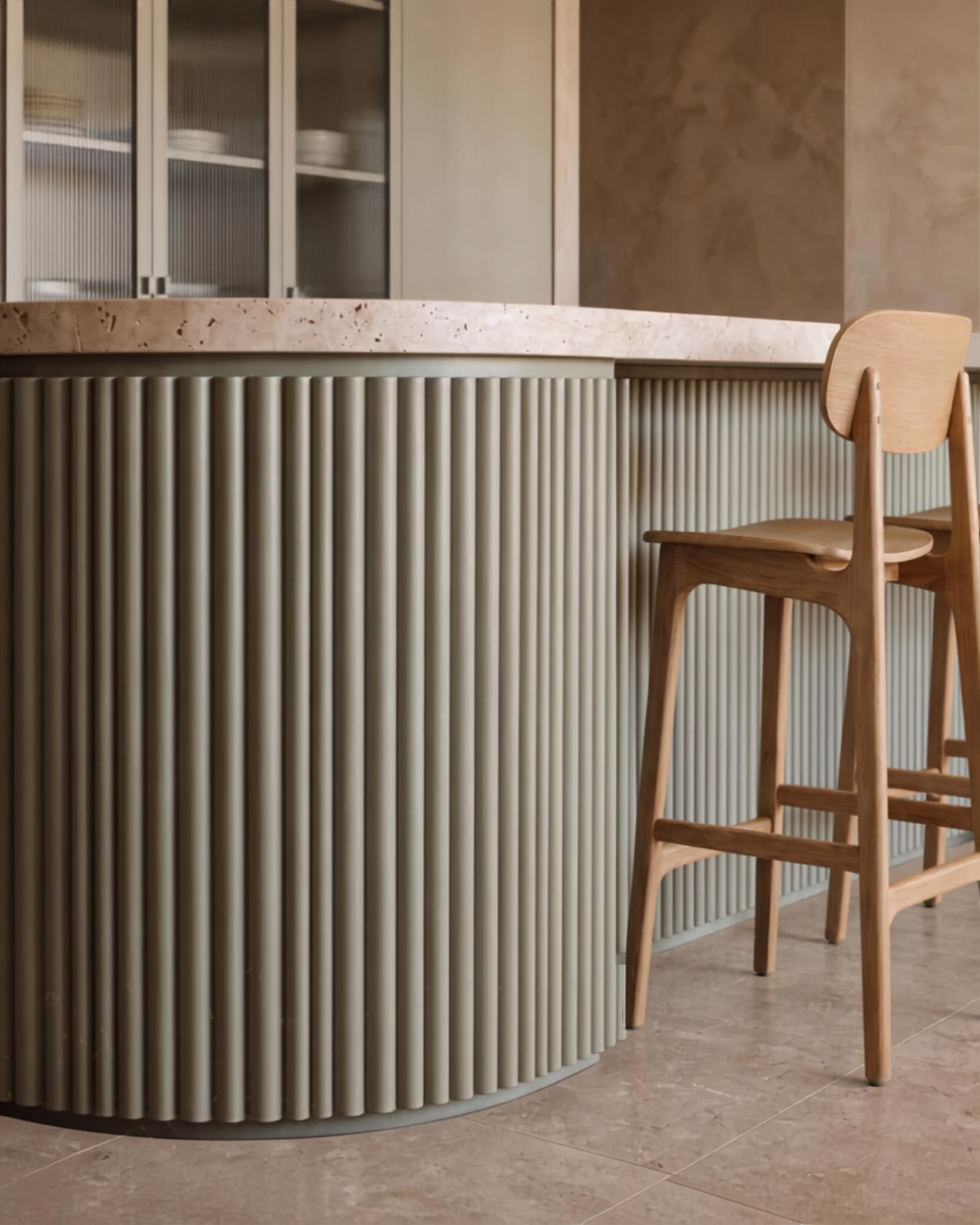 Curved celadon fluted island with a textured stone countertop and natural oak barstool.