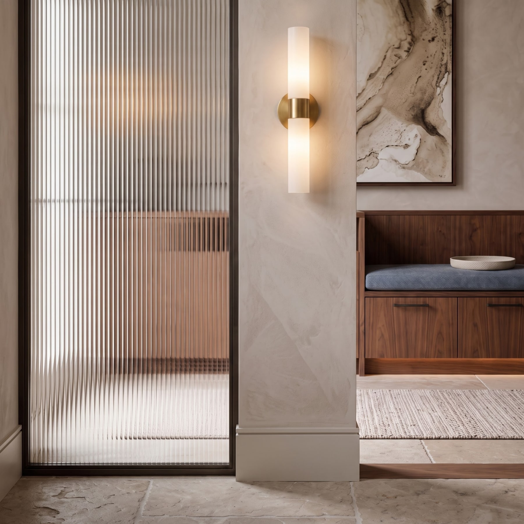 Vestibule detail featuring a ribbed glass panel, illuminated brass wall sconce, and built-in walnut bench.
